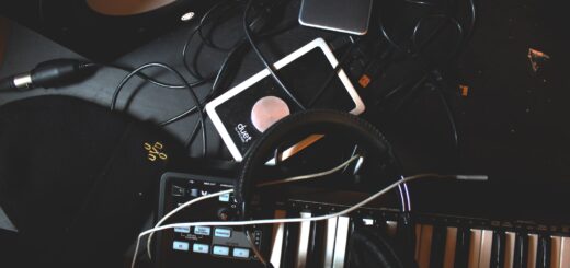 flat-lay photo of headphones, MIDI keyboard, and speaker on black surface